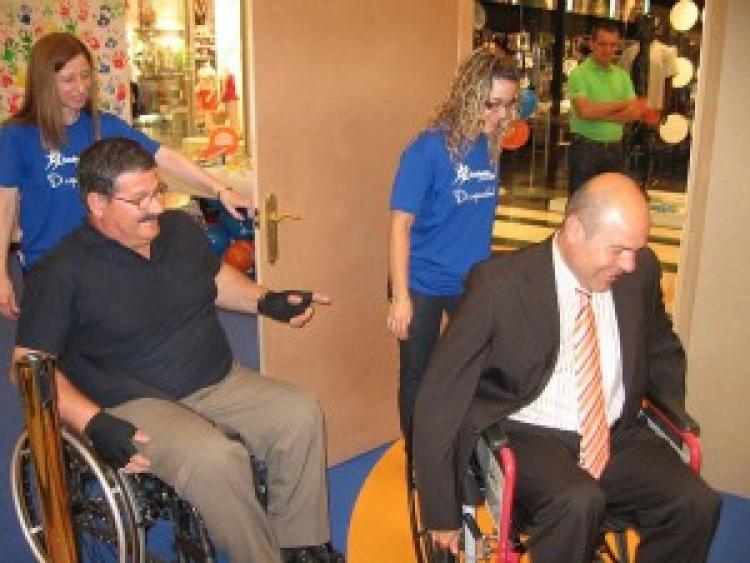 Dos personas en sillas de ruedas en la exposición DiCapacidad